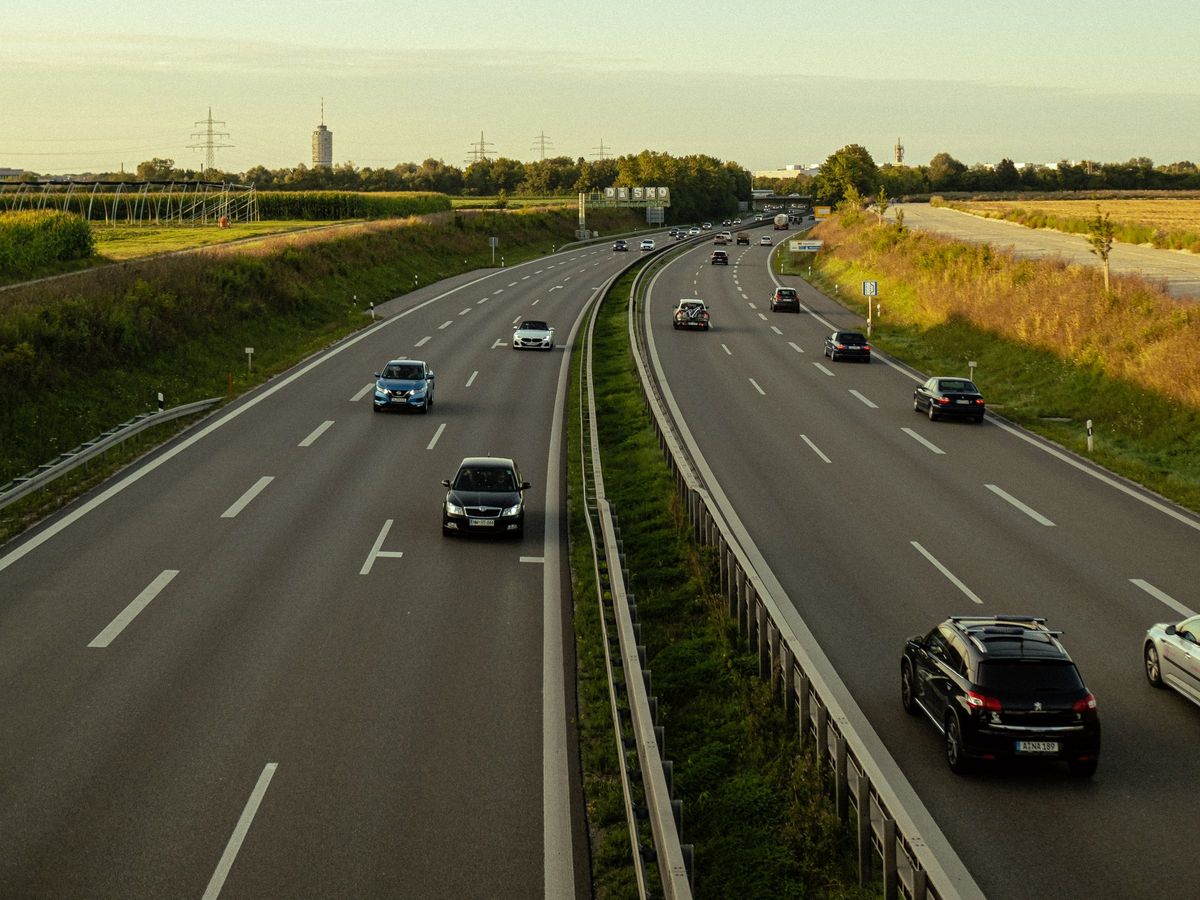 Pkw auf einer mehrspurigen Autobahn im Abendlicht